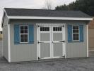 Pine Creek 10x16 Cottage with Light Gray walls, White trim and Light Blue Z-Style shutters, and Charcoal shingles